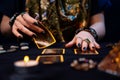 Cartomancy. Fortune-telling on cards. A fortune teller lays out Tarot cards. Close up of hands. The concept of