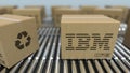 Carton boxes with IBM logo move on roller conveyor. Realistic 3D rendering