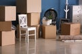 Carton boxes and interior items on floor in room. Moving house concept Royalty Free Stock Photo