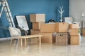 Carton boxes and interior items on floor in room. Moving house concept