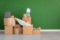 Carton boxes and interior items near color wall in room. Moving house concept Royalty Free Stock Photo