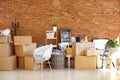 Carton boxes and interior items in room. Moving house concept Royalty Free Stock Photo