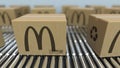 Carton boxes with MCDONALD`S logo move on roller conveyor. Realistic 3D rendering