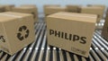 Carton boxes with PHILIPS logo move on roller conveyor. Realistic 3D rendering