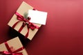 Carton gift box decorated red ribbon bow and blank paper card mockup on marsala red background. Flat lay, top view. Christmas gift Royalty Free Stock Photo