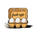 A carton with the words fresh eggs holds three eggs, surrounded by a few pieces of straw Royalty Free Stock Photo