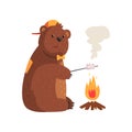 Cartoon bear frying marshmallow on fire in woods. Adorable