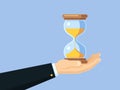 Cartoon businessman hand holding antique hourglass. Time management vector business concept with sand clock