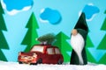 Cartoon composition of a small red car and a green Christmas gnome Royalty Free Stock Photo