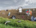 Cartoon Farmer with a Wheelbarrow in a Polluted Field