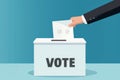 Cartoon hand casting a vote into a ballot box, against a dynamic orange background Royalty Free Stock Photo