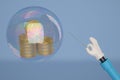 A cartoon hand with a needle pierces the bubble with gold coin s