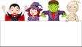 Cartoon kids with Halloween costume with blank sign Royalty Free Stock Photo