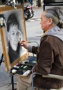 A cartoonist, with a portrait of Paul McCartney