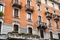 Carved balconies and stucco stone frames over the windows of the old house. Milan, Italy