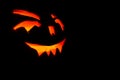 Carved face of pumpkin glowing on Halloween black background Royalty Free Stock Photo