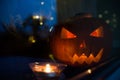 The carved face of pumpkin glowing on Halloween on green background Royalty Free Stock Photo
