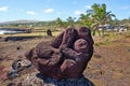 Carved figure in volcanic stone near the village of Hanga Roa, on Easer Island, against the ocean and a blue sky covered