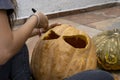 Carved Halloween pumpkin, jack lantern, with carving tools. Spooky laughing, scary head. Royalty Free Stock Photo