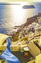 Carved houses terrace and cruise ship passing Oia Santorini Greece