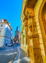 Carved limestone Atlases on facade of historic building on Celetna street and Powder Tower on background, Prague, Czechia