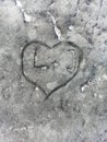 Carved love design in stone, heart with plus and letters on rock, carving, close uo, grey background