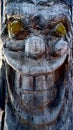 Carved face on a tree trunk disturbing smile Royalty Free Stock Photo
