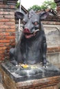 Vintage carved and painted wild boar statue outside a temple in Bali Indonesia