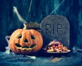 Carved pumpkin, gravestone and Halloween candies