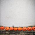Carved pumpkins Jack-o`-lanterns under a white wall. Graphic resource, halloween background concept