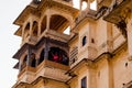 Carved sandstone exterior walls of the udaipur palace with arches, balcony and windows