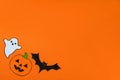 Carved scary figurines of ghost, pumpkin and bat on a yellow background, the concept of the holiday Halloween, space for