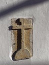 A Carved Stone Cross embedded into the Walls of a House in a street of the Portuguese Town of Estoi.