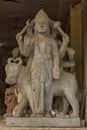 A carved stone statue of a Hindu God standing in the entrance of a shop in Delhi