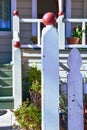 Carved wood finials painted earth red on white posts