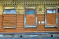 Carved wooden antique windows, boarded up. A detail of an old abandoned house Royalty Free Stock Photo