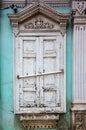 Carved wooden window with platbands and closed shutters, a fragment of the facade of an old building Royalty Free Stock Photo