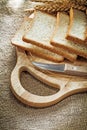 Carving board kitchen knife sliced bread wheat ears on sacking b Royalty Free Stock Photo