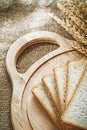 Carving board sliced bread wheat ears on sacking background Royalty Free Stock Photo