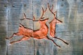 Carving of pair of deer in wooden panels