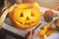 Carving pumpkin into jack-o-lantern for halloween holiday decoration at home kitchen Royalty Free Stock Photo