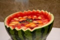 Carving watermelon with cold fruit soup inside. Carved watermelon bowl