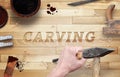 Carving word carved in wood with hammer and chisel.