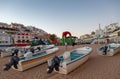 Early evening view of cave tour boats on the beach with Carvoeiro town square behind.