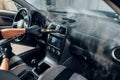 Carwash, worker cleans salon with steam cleaner