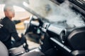 Carwash, worker cleans salon with steam cleaner