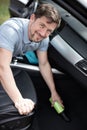 carwash worker cleans seats with steam cleaner Royalty Free Stock Photo