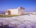 Caryatids female statues on Erechtheion ancient temple under sunny blue sky, with Athens urban area in the background. Royalty Free Stock Photo