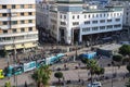 Top view of Casablanca square with clipped trees, tram and lots of people