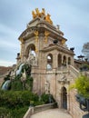 Water cascade and stone monument with an arch and golden statues at Ciutadella Park